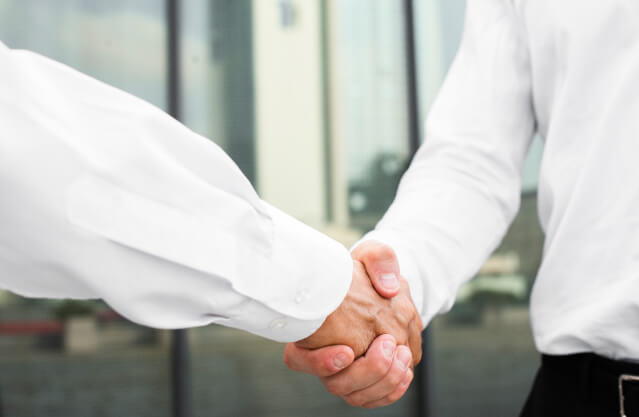 2 Geschäftsmänner geben sich einen Handschlag
